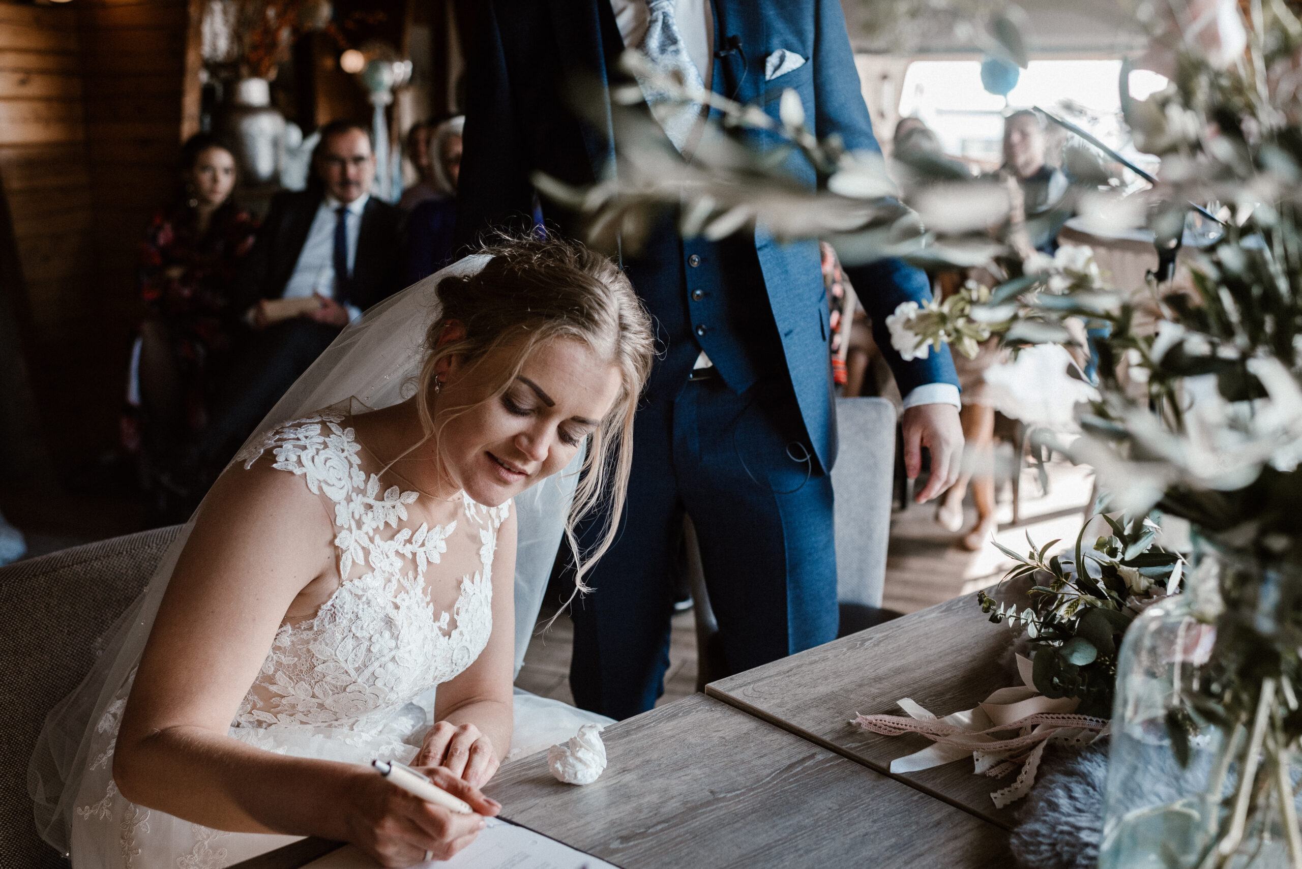 Bruidspaar tekent het trouwboekje tijdens de ceremonie