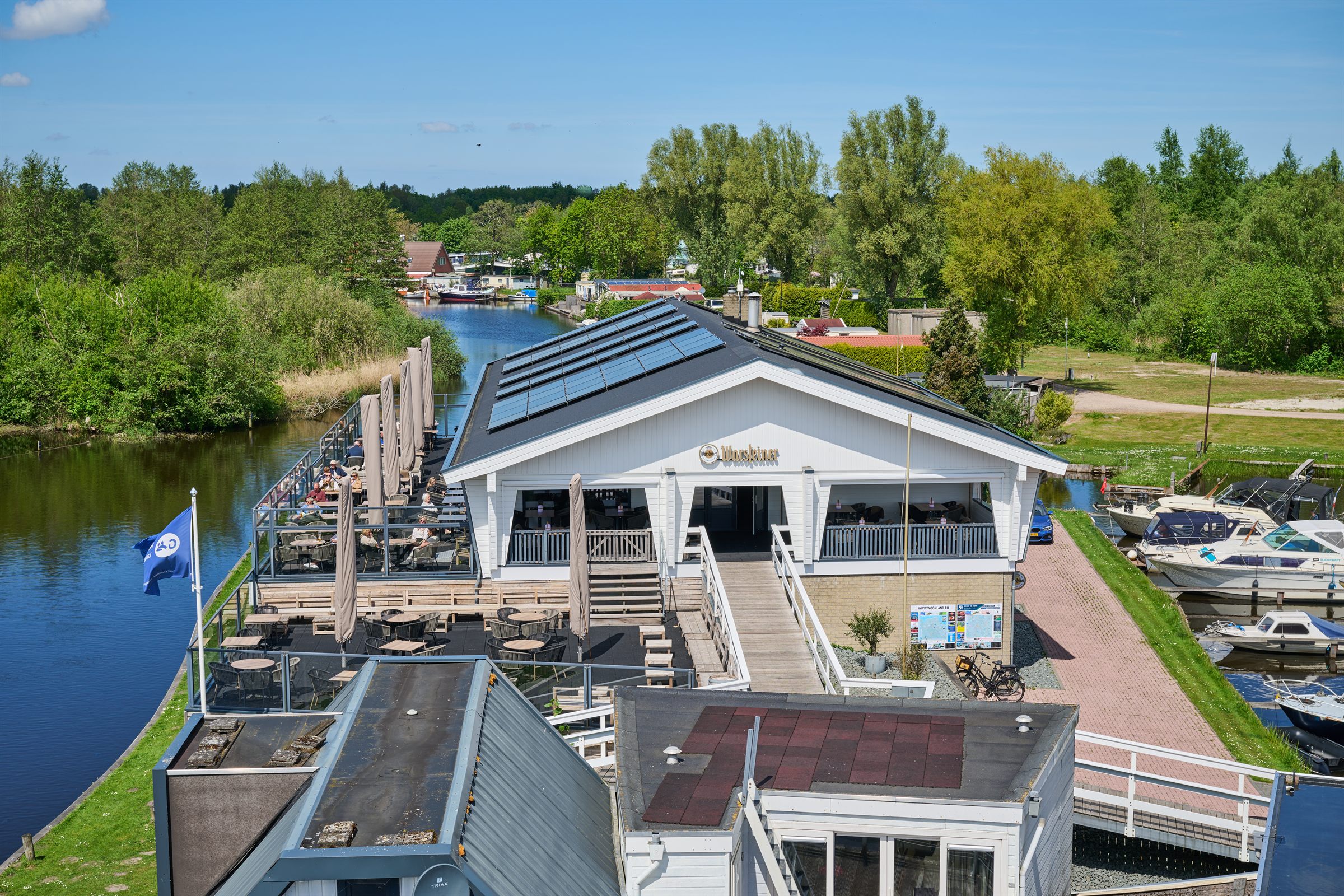 Luchtfoto van het paviljoen met terras en jachthaven